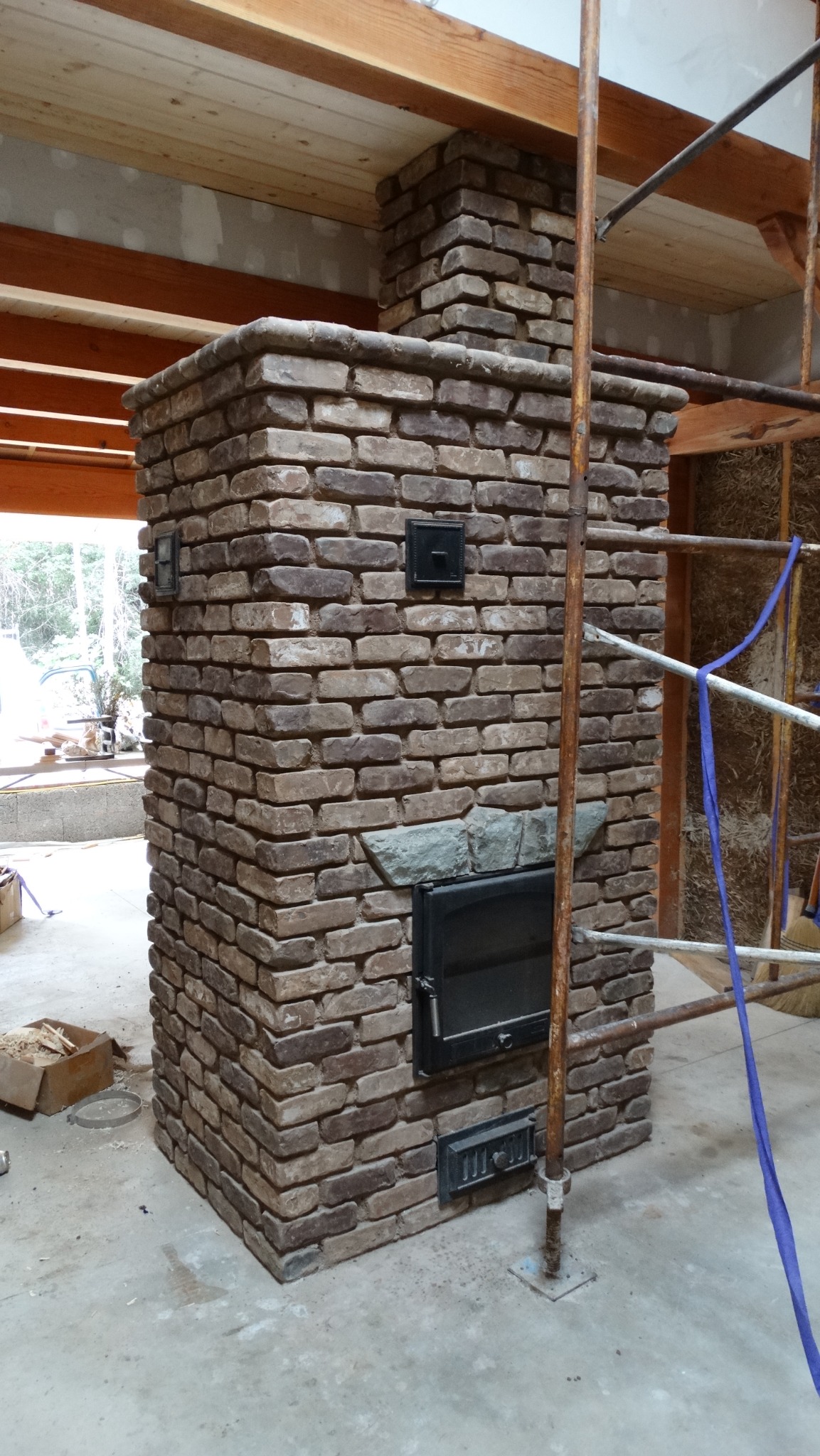 Hand-built reclaimed-brick masonry heater under construction